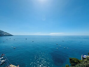 A coastal view with boats on the water, a clear sky, and a mountainous landscape in the background. - YourHome - La Casa di Chiara (Positano)