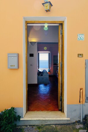 A doorway leading to a room with a view of the sea, a small window, and a number '53' sign on the wall. - YourHome - La Casa di Chiara (Positano)