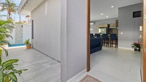 A modern interior with a dining area, kitchen, and a small outdoor space with a pool. - Casa Bella Puerto Vallarta (Puerto Vallarta)