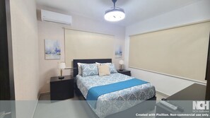 Una habitación de hotel con cama, mesitas de noche, lámpara, aire acondicionado y luz de techo.