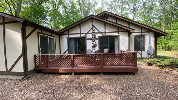 A cabin with a covered porch, large windows, and a chimney. - Charming 3-bedroom cottage with AC in marvelous Saugatuck close to trails (Saugatuck)