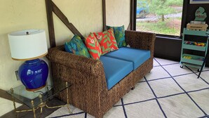A wicker sofa with colorful cushions, a glass table with a blue vase, and a sign reading "Gone to the beach". - Charming 3-bedroom cottage with AC in marvelous Saugatuck close to trails (Saugatuck)
