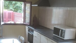 Une cuisine compacte équipée d’une table à manger, d’un four à micro-ondes et d’une cuisinière.