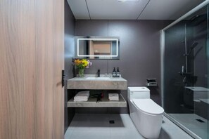 A modern bathroom with a toilet, sink, and shower. - Longgang Hongmao Film Hotel (Longgang)