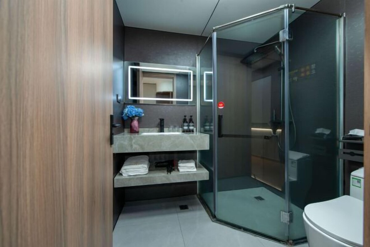 Une salle de bain moderne avec une douche à parois de verre, un meuble-lavabo avec un miroir et des toilettes.