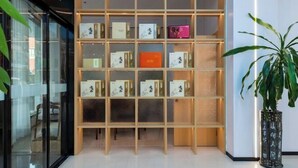 A modern interior with a wooden shelving unit displaying various items. - Longgang Hongmao Film Hotel (Longgang)