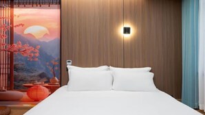 A bedroom with a wooden headboard, a bed with white bedding, a wall-mounted light, and a view of cherry blossoms. - Longgang Hongmao Film Hotel (Longgang)