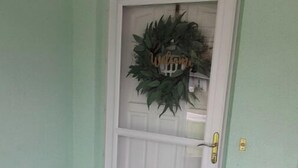 A white door with a wreath and a small house decoration above it. - Entire 2 bedroom home w/1 car garage in Inverness (Inverness)