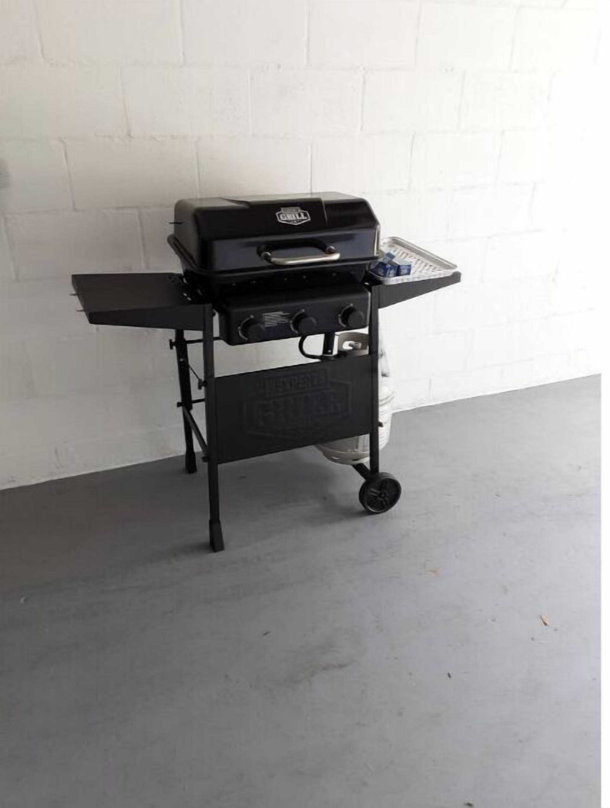 Un barbecue portable doté d’un brûleur latéral et d’un petit chariot.