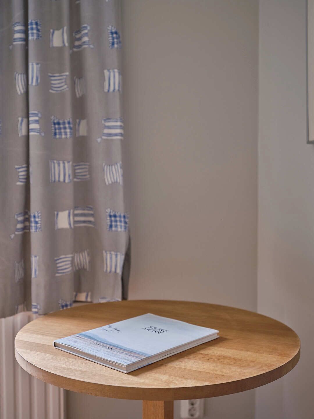 Una mesa redonda de madera con un libro titulado 