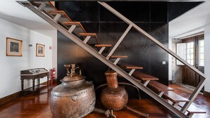 A staircase with wooden steps and metal railings, leading to a dark room with a black wall. - Casa do Lagar (Cabeceiras de Basto)