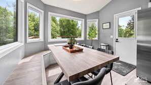 Cocina moderna con una isla grande, abundante luz natural proveniente de amplios ventanales y vistas al exterior con vegetación.