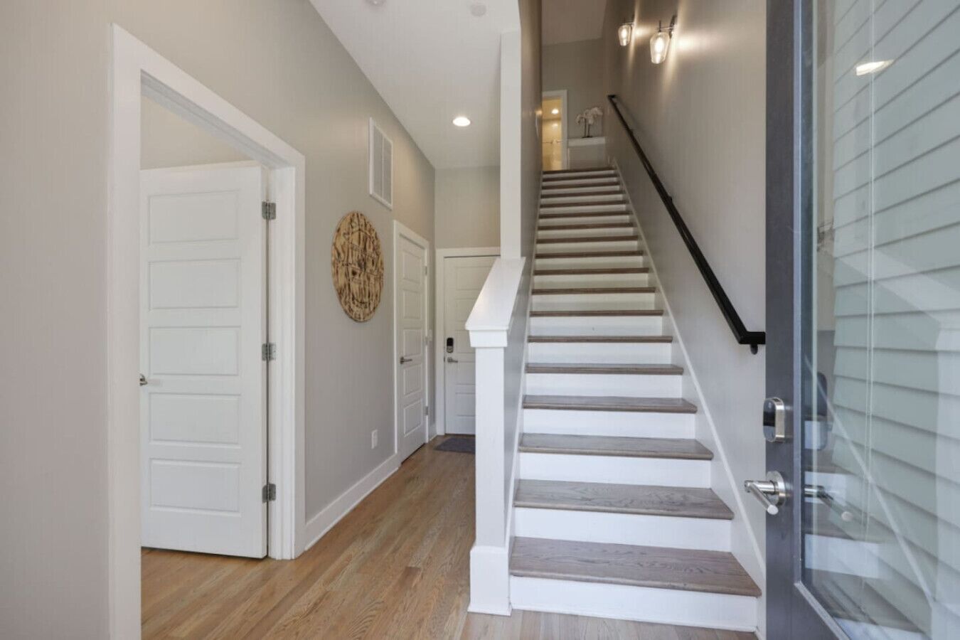 Un escalier avec une rampe en verre menant à l’étage supérieur.