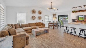 A spacious living area with a large sectional sofa, a dining table with chairs, and a kitchen area with bar stools. - P61 - 2 Bed, 2 Bath with coastal chic vibe and private pool. (Marathon)
