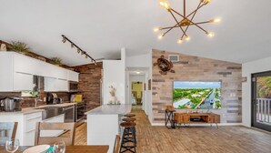 A modern kitchen with white cabinets, a wooden island, and a dining area with a wooden table and chairs. - P61 - 2 Bed, 2 Bath with coastal chic vibe and private pool. (Marathon)