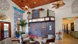 A lobby with a seating area, a balcony with a sign reading "Paradise Palms Cinema," and an exit sign. - Paradise Palms 4BR | Private Pool & Themed Rooms (kissimmee)