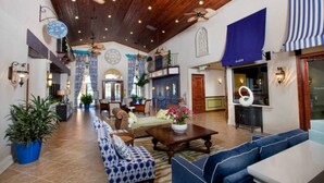 A spacious lobby with high ceilings, wooden beams, and a central seating area with sofas and a coffee table. - Paradise Palms 4BR | Private Pool & Themed Rooms (kissimmee)