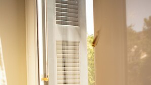 Une porte avec une fenêtre, une poignée de porte et une vue sur l’extérieur.