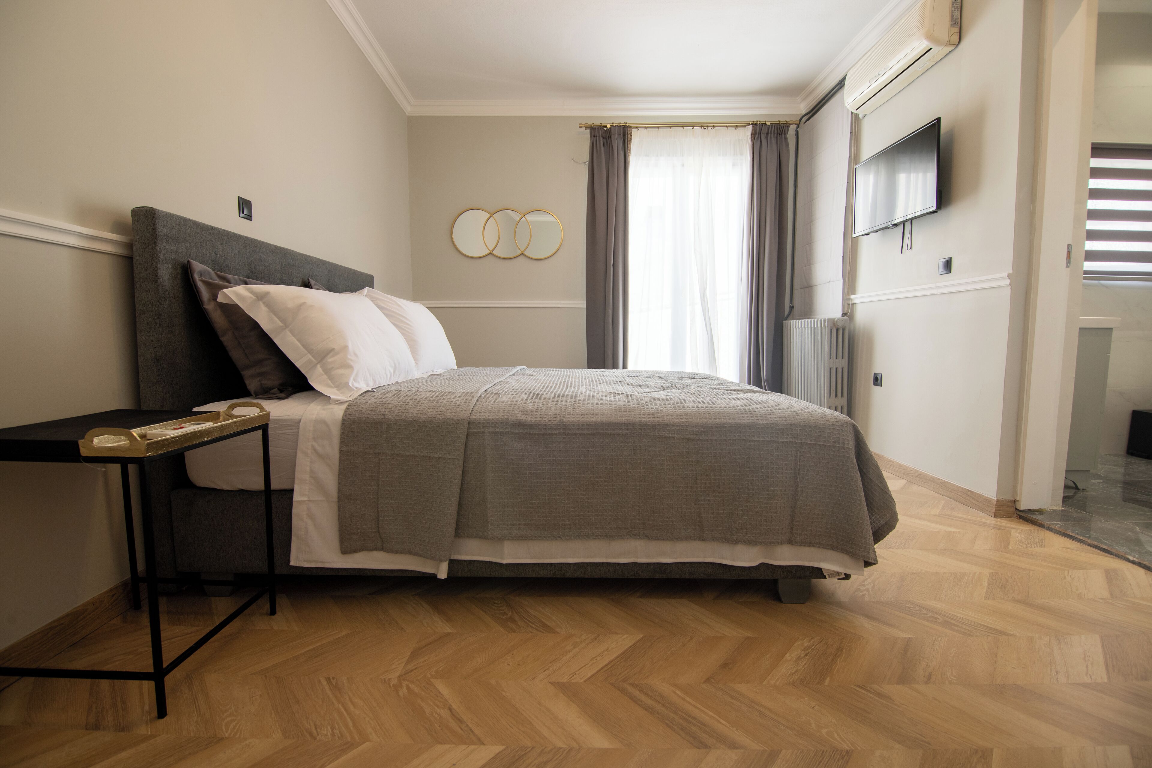 Ein Schlafzimmer mit Bett, Nachttisch und einem an der Wand befestigten Fernseher.