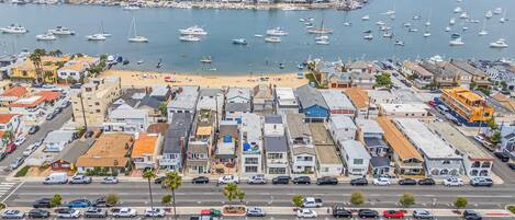 A coastal town with a marina, sandy beach, and a variety of buildings including residential and commercial properties.