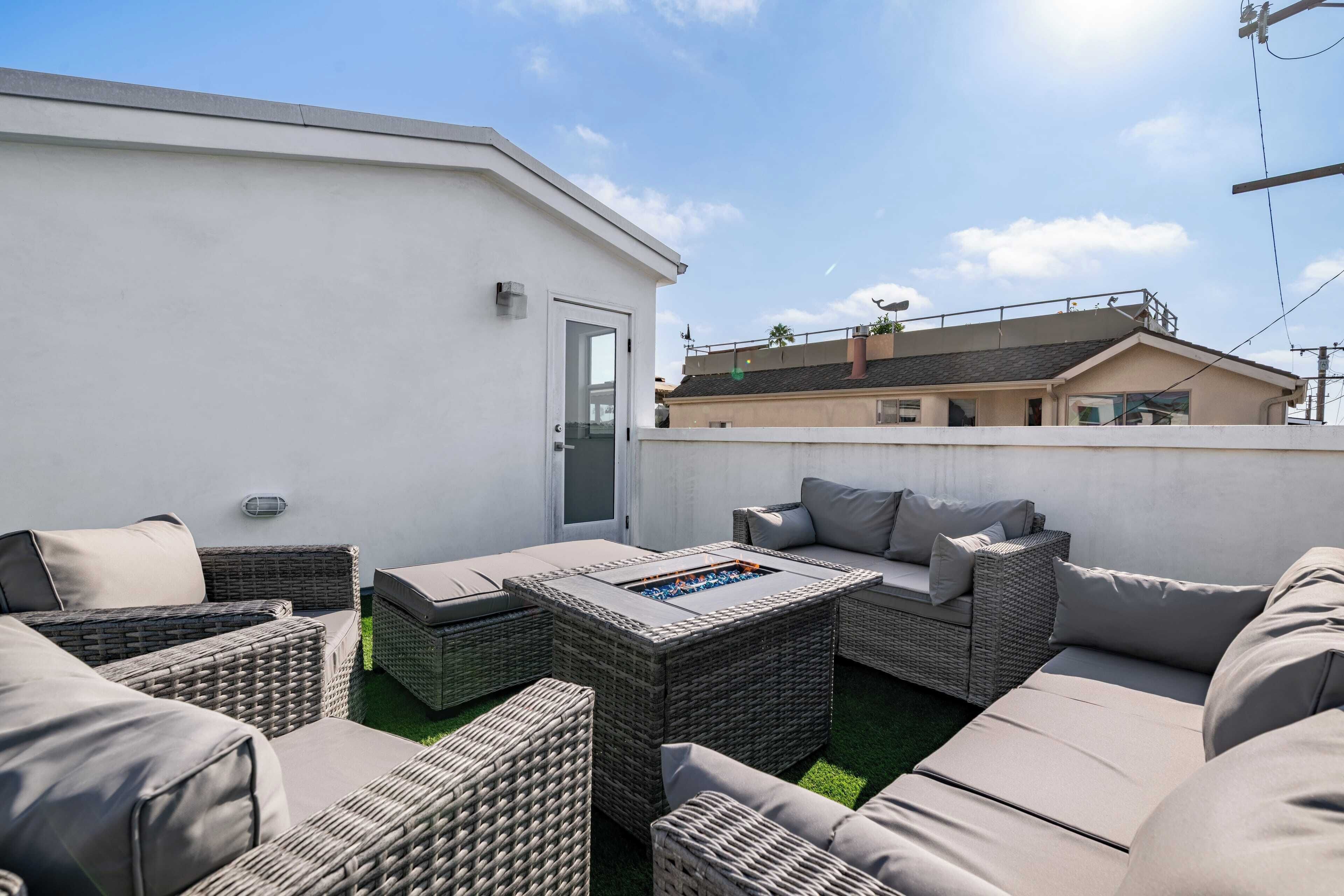 Eine Terrasse im Freien mit Korbmöbeln und einem Feuerkorb.
