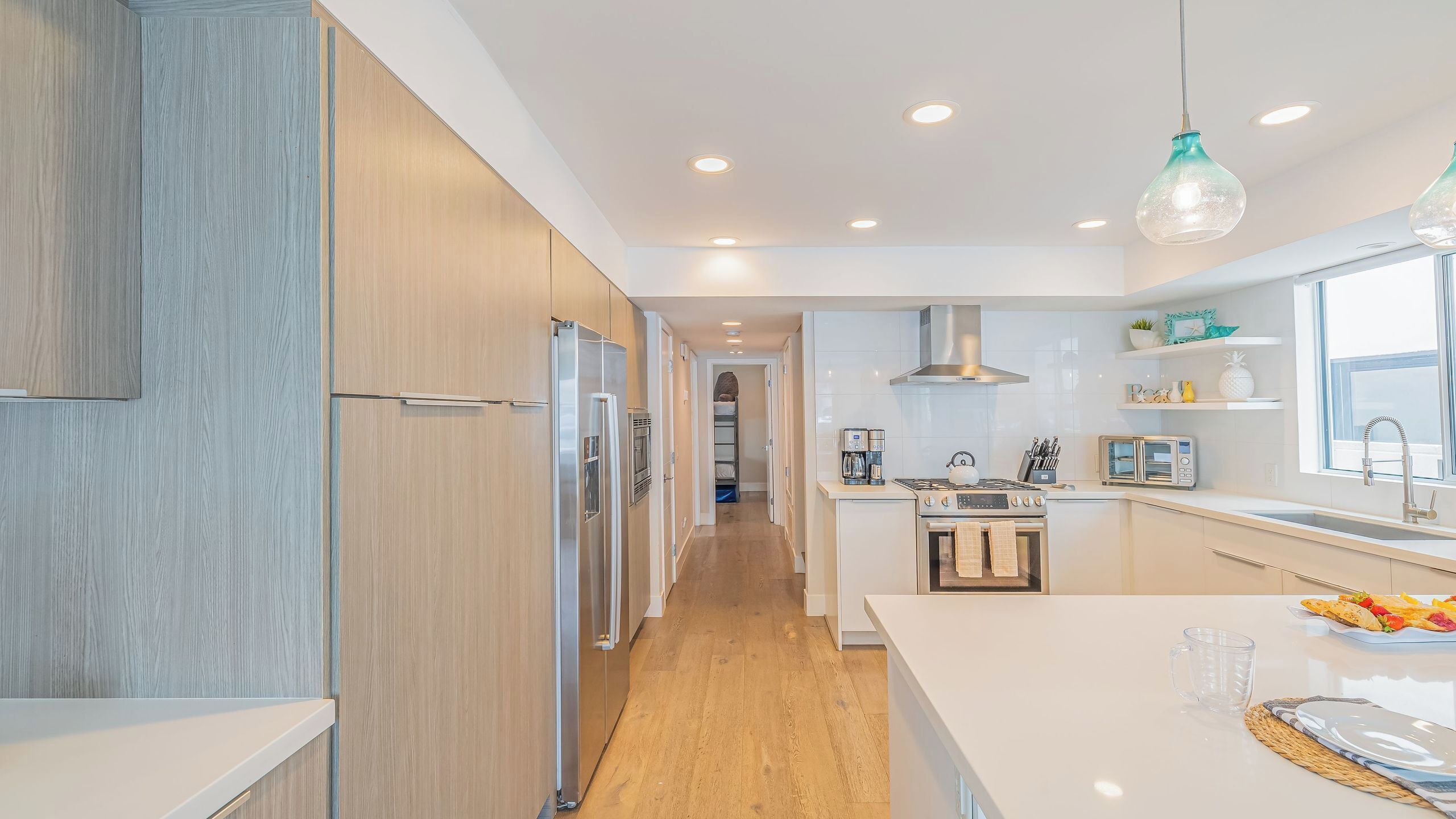A modern kitchen with wooden cabinets, a central island, and a built-in oven.