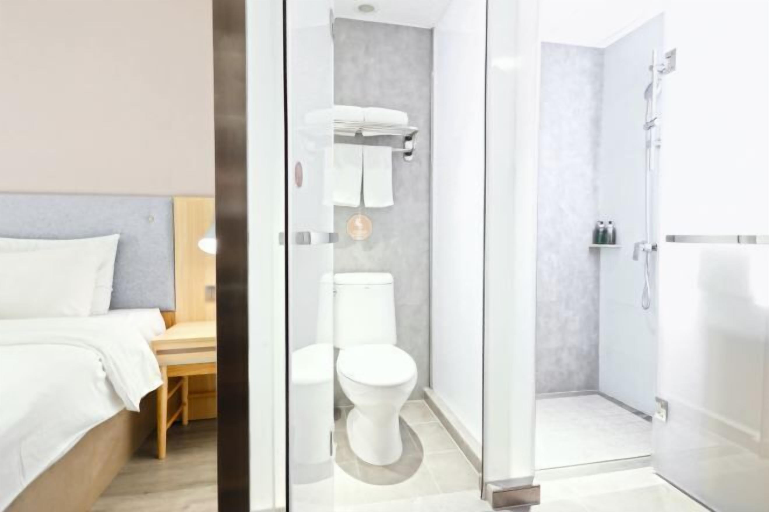 Un baño moderno con mampara de vidrio, inodoro y bañera.