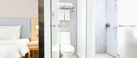 Un baño moderno con mampara de vidrio, inodoro y bañera.