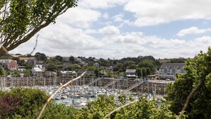 A marina with numerous boats docked, surrounded by residential buildings and greenery. - La Petite Mouette - Maison au port de Dahouët (Pléneuf-Val-André)