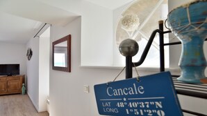 A room with a blue sign indicating the location as Cancale, with coordinates.