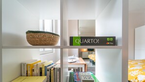 Ein Bücherregal mit Büchern, ein gewebter Korb und ein Gesellschaftsspiel.