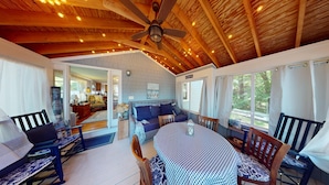 A cozy room with a wooden ceiling, a ceiling fan, a dining table with chairs, and a sofa. - "Charming 2-Bedroom Home in Narragansett with Private Beach Access and WiFi" (Narragansett)