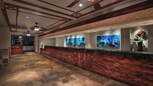 A reception area with a stone floor, wooden reception desk, and wall-mounted artwork. - OceanFrnt-1BDRm/1 BATH-Marriott Lahaina/NapiliTower Maui-Full Resort-Real Owner (Lahaina)