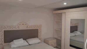 A bedroom with a bed, a nightstand, a wardrobe, and a mirror. - Dar Lella (Bizerte)