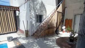 A residential building with a staircase leading to the upper floor, a small window, and a door. - DepartamentoLaCascada (Termas de Rio Hondo)