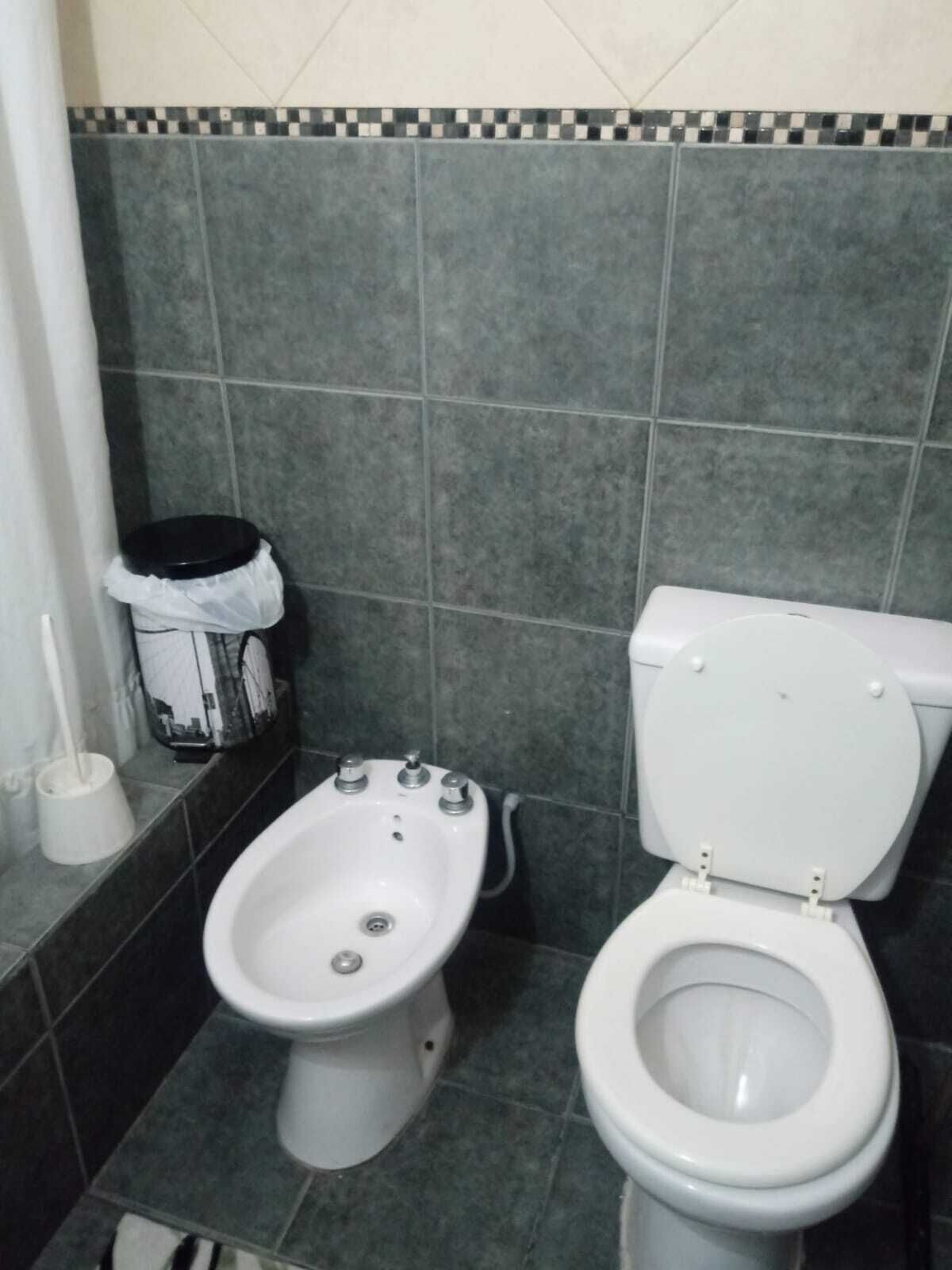 Un bagno con bidet, water e cestino.