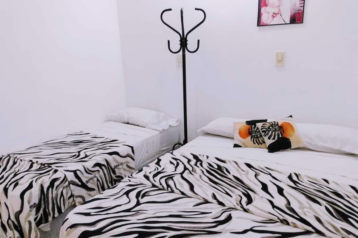 Una habitación con dos camas, cada una con ropa de cama a rayas de cebra.