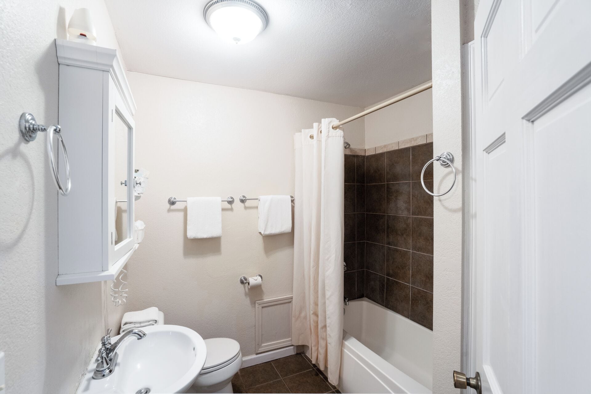 Une salle de bain comprenant des toilettes, un lavabo et un espace douche.