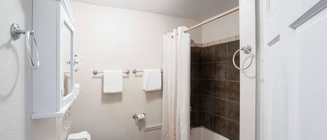 Une salle de bain comprenant des toilettes, un lavabo et un espace douche.