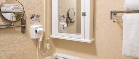 A bathroom with a pedestal sink, a mirror cabinet, a towel rack, and a toilet.