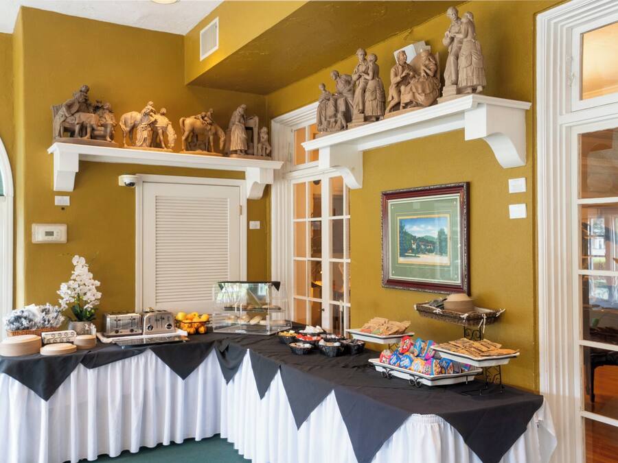 A buffet table with various food items and a statue collection above it.