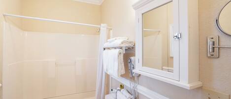 A bathroom with a bathtub, a toilet, a sink, and a mirror.