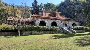 Un bâtiment en pierre, doté d’un toit en tuiles, de fenêtres en arc de cercle et d’un escalier menant à l’entrée.