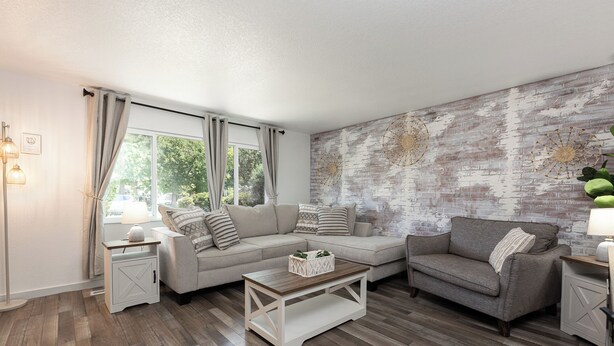 A living room with a sofa, two armchairs, a coffee table, and a brick-patterned wall. - 2 Condos, Minutes From Downtown, Parks, and Freeway! (Boise)