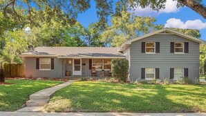 A two-story house with a front porch, a garage, and a well-maintained lawn.