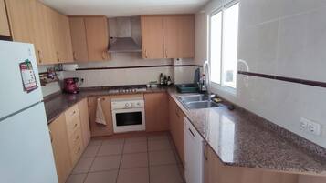 Een magnetron, een vaatwasser, kookgerei, borden en bestek