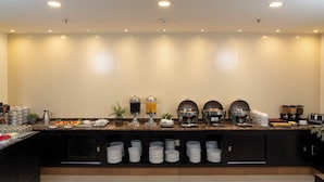 A buffet setup with multiple food stations, a coffee machine, and a beverage dispenser. - Garden Park San Luis Potosí (San Luis Potosi)