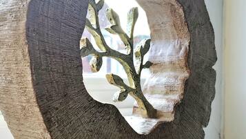 Een groot, abstract beeldhouwwerk met een ruwe textuur en een centrale opening die een vertakkende structuur onthult.