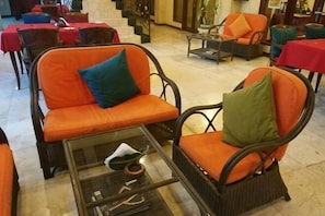 A seating area with wicker chairs and a glass table, featuring a red and blue tablecloth. - Bali Emerald Villas (Bali)