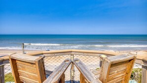 Eine Holzterrasse mit Blick auf den Ozean.